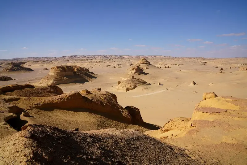 Layered rock formations across a broad Egyptian desert landscape