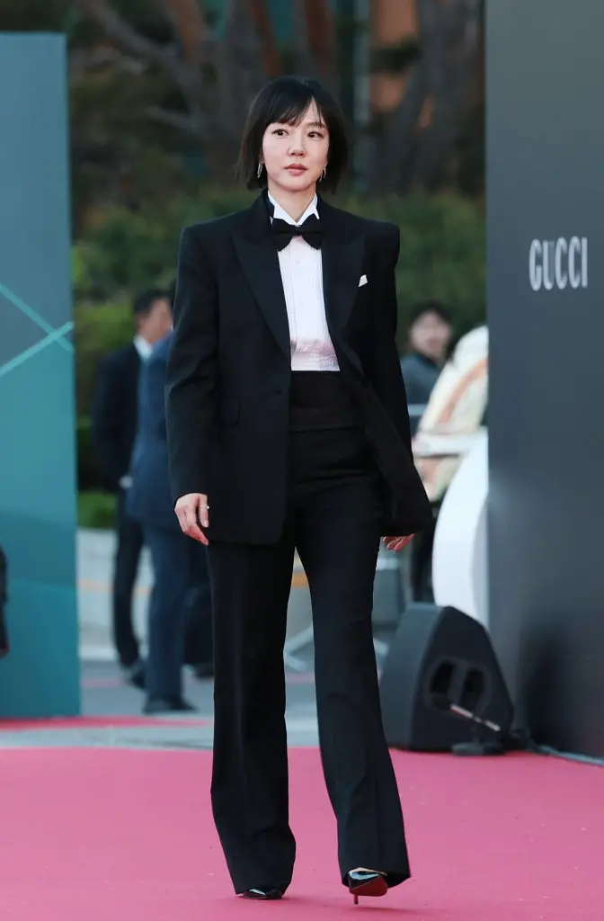 Lim Soo-jung  in a tuxedo with a bow tie walking down a red carpet at an event, with blurred attendees in the background.