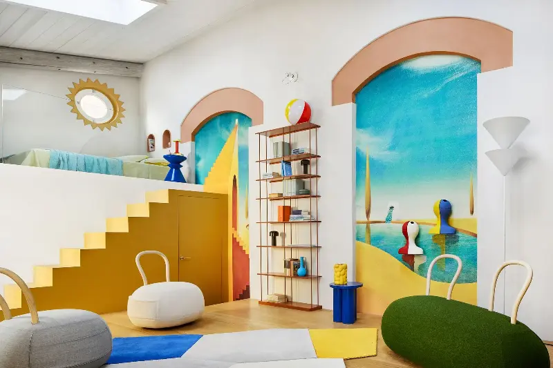 Dopamine decor is a key theme across the micro-apartment, with Opinion Ciatti's Yum Yum chairs, a cobalt blue Oly Stool from noo.ma, and a Krossing Maxi Bookcase from Kriptonite littered with colorful knickknacks. (Image credit: Thomas Pagani. Design: Studio Paradisiartificiali with Owen Gent. Styling: Giulia Taglialatela)
