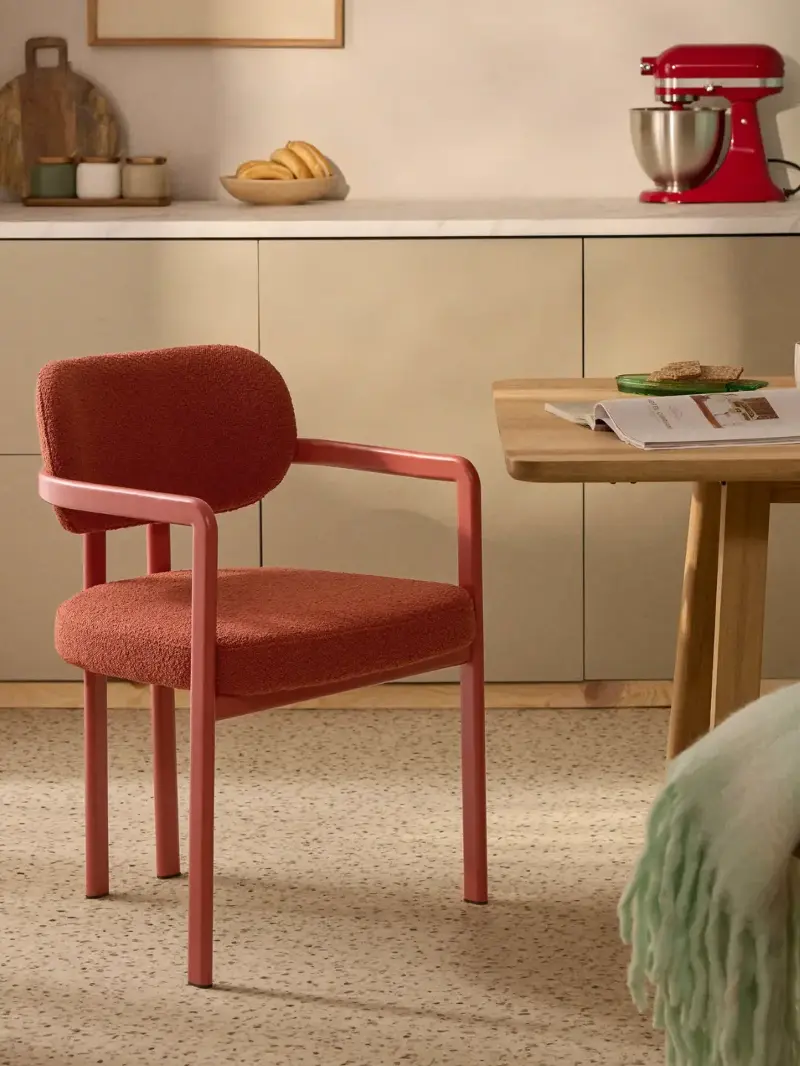 A coral bouclé dining chair from Westwing