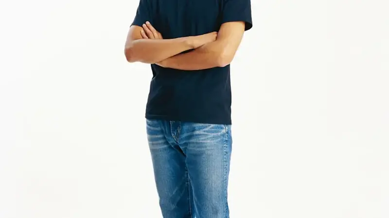 Young man standing with arms crossed, portrait