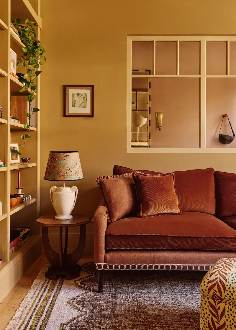 In well-lit rooms, warm paint shades like Farrow & Ball's Biscuit feel like a livable take on ochre.  (Image credit: Kensington Leverne for Golden)