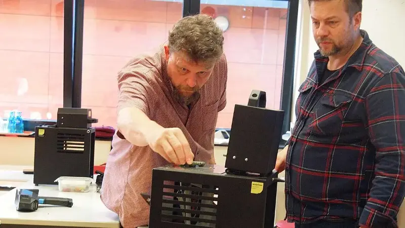 Dr. Axel Posluschny, Archäologe und Leiter des Forschungszentrums an der Keltenwelt, positioniert den Armreif in der Probenkammer. Rechts daneben: Toni Walter, Schulungsreferent und technischer Berater bei Analyticon.