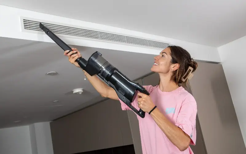 Lucy hoovers her air ventilation duct where hair can easily build up without regular removal - Rii Schroer