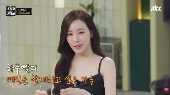 A woman with long hair is sitting at a table, wearing a black tank top, and speaking earnestly. Text in Korean is visible beside her.