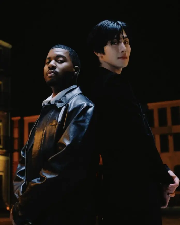 Ahn Hyo-seop and Khalid standing back to back in a dimly lit urban setting, Khalid wearing a black leather jacket and Ahn Hyo-seop in a black coat.