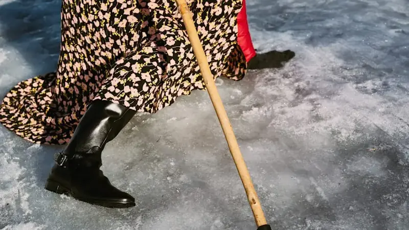 Woman walking on icy street in winter.
