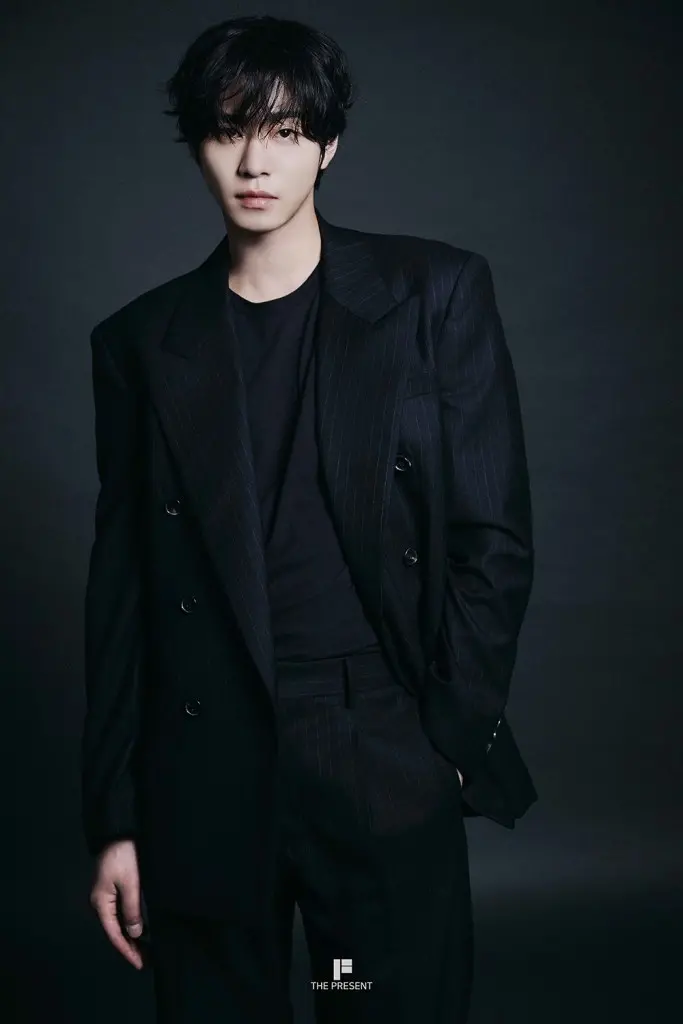 Ahn Hyo-seop with stylish, tousled hair wearing a black pinstripe suit and a fitted black shirt, posed against a dark background.