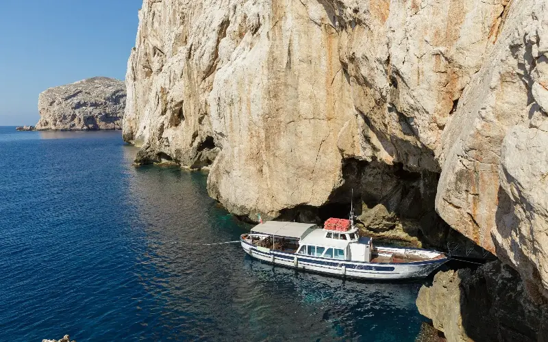 Boat tours take you to explore the cliffs and caves around the island, where dolphins can be seen if you’re lucky - gianluigibec / Alamy Stock Photo