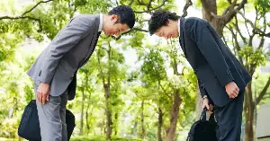 In Japan, the depth of a bow carries specific institutional meaning — a 15-degree bow is a casual greeting between colleagues, a 30-degree bow is a formal greeting to a client or customer, and a 45-degree bow is reserved for serious apology, gratitude, or the greeting of someone whose social standing significantly exceeds your own