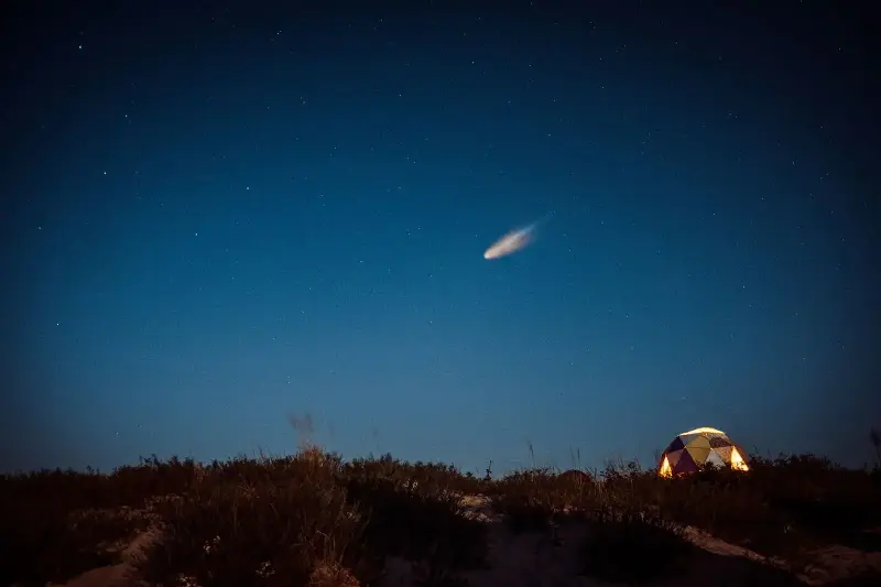 A bright meteor streaking across a starry night sky.