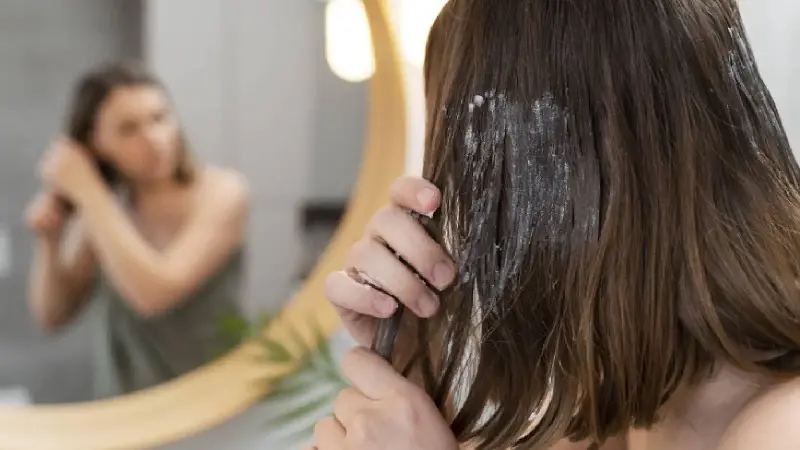A woman putting hair mask