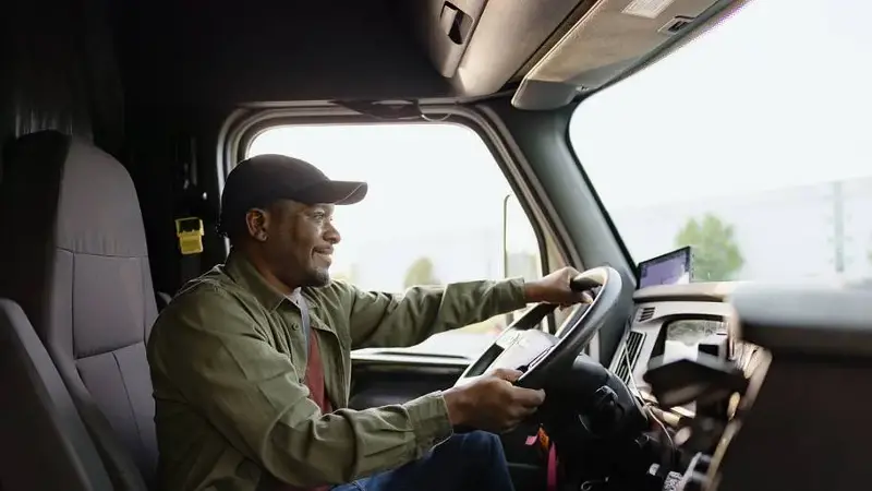 Truck driver smiling while driving his truck
