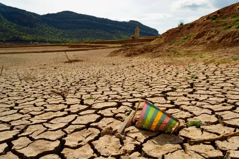 Scorched earth and earth clods are seen on dry land caused by drought and lack of rain due to climate change. Concept of water shortage and climate crisis, cracked earth and dry soil.