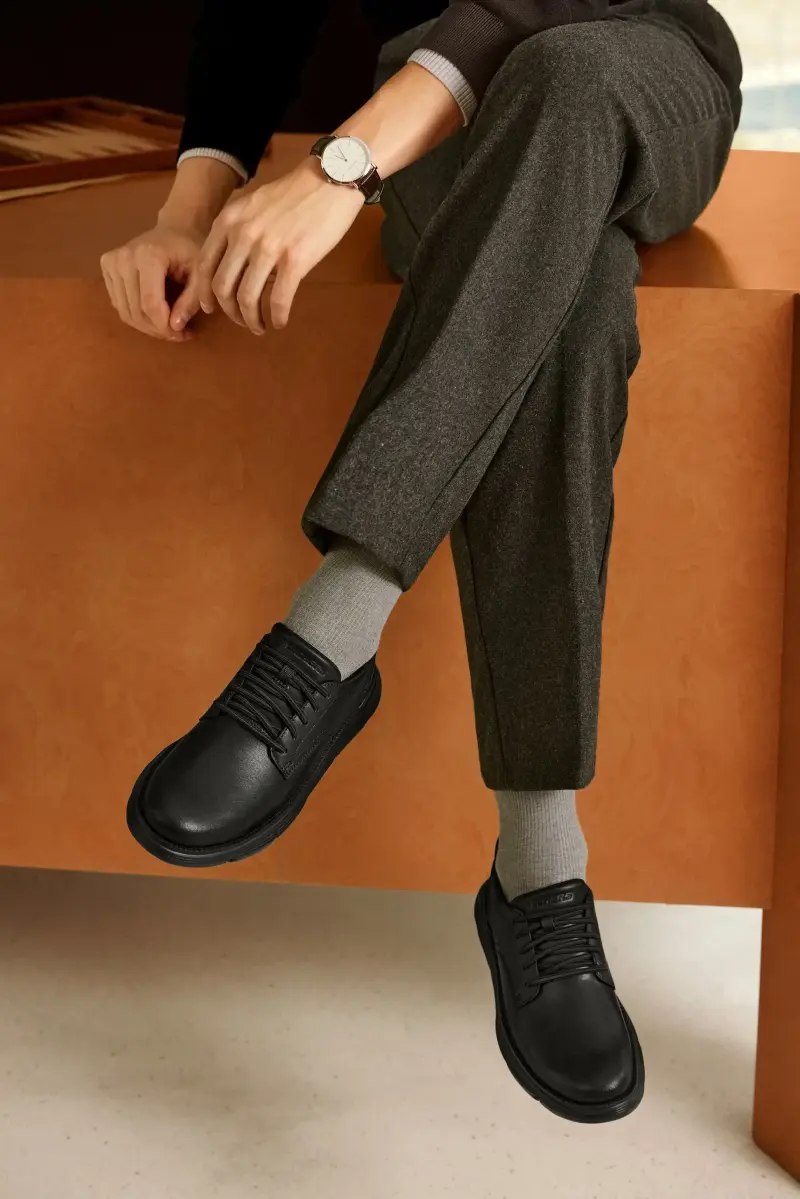 Black leather Skechers Garza Duran shoes worn with grey socks and dark wool trousers