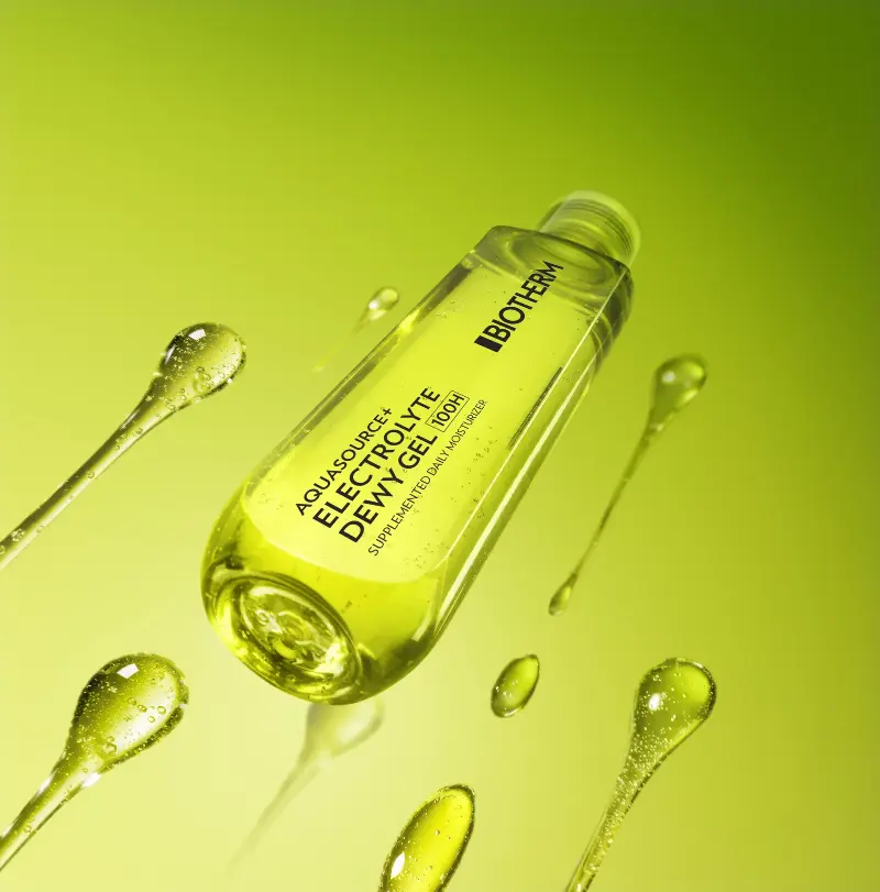 Biotherm Aquasource+ Electrolyte Dewy Gel bottle with floating gel droplets on a green gradient background