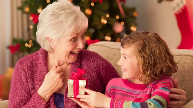 Girl and grandmother holding Christmas gift