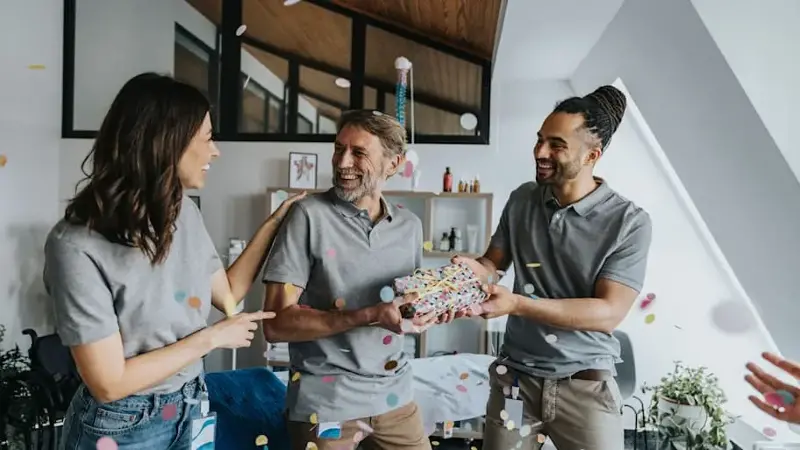 Physiotherapists celebrating birthday of male colleague in practice