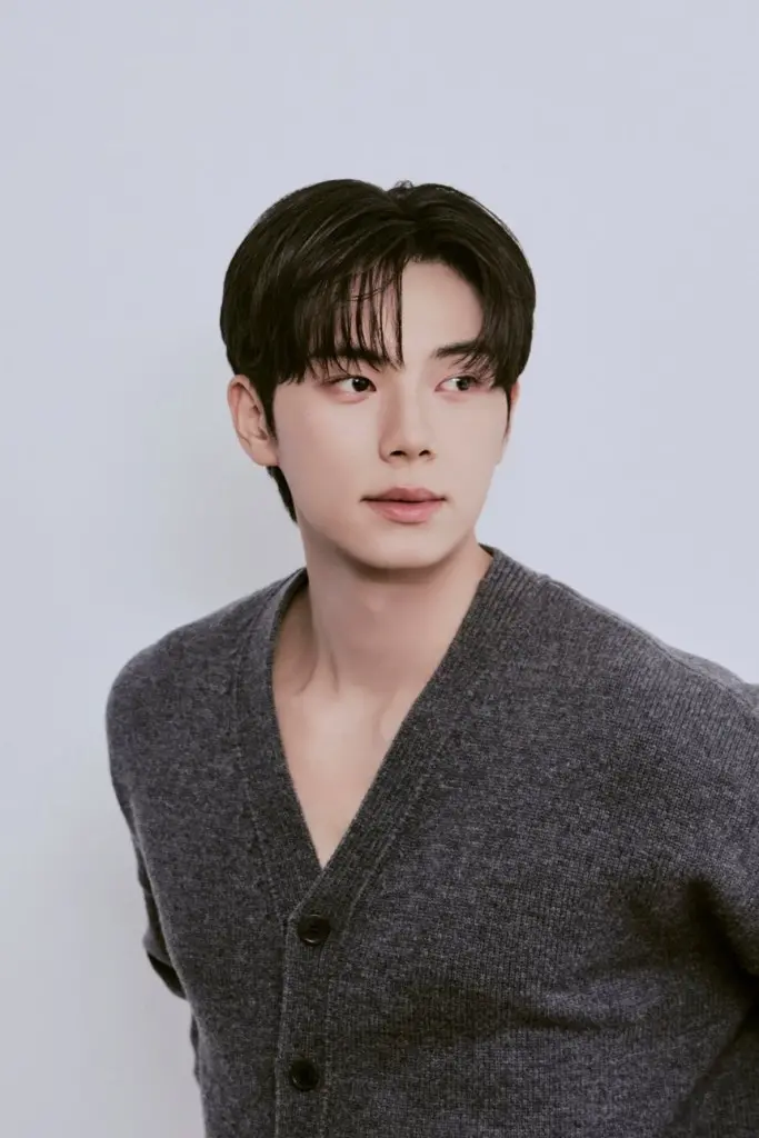 Lee Chae-min with dark hair and a casual gray cardigan, looking to the side against a light background.