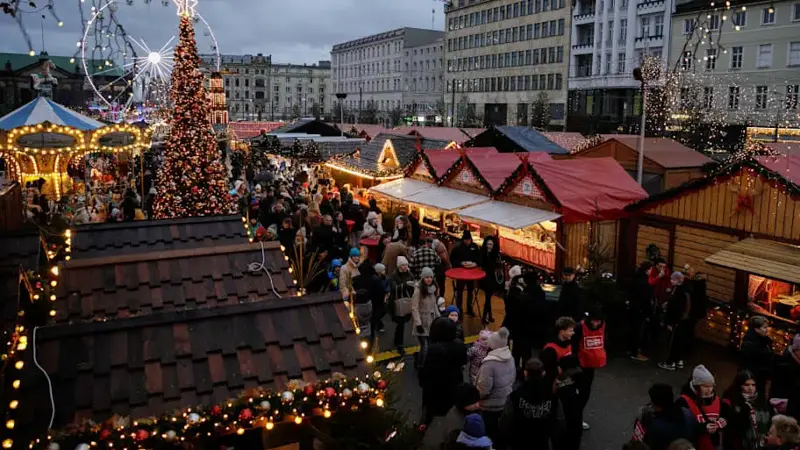 People walk between the stalls at the Poznan Christmas market