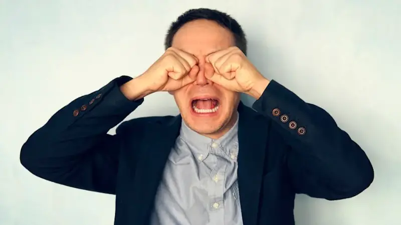 Portrait of a young businessman crying. man cries like a child. guy in the suit yells with his mouth wide open. Psycho worker.