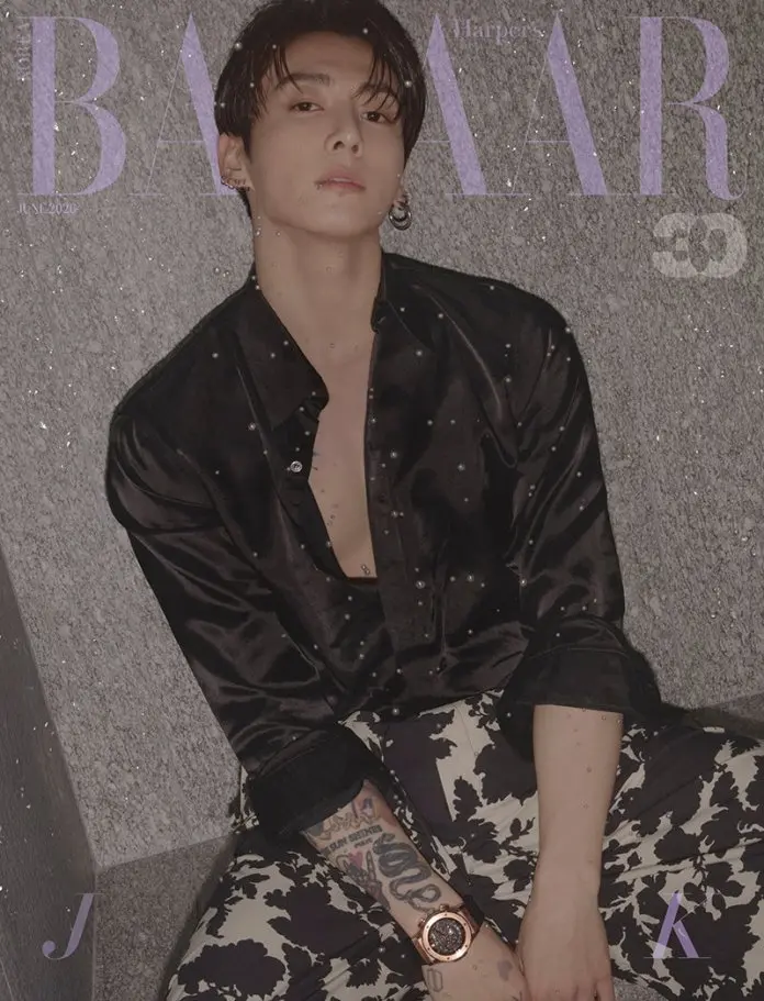 Jungkook dressed in a black button-up shirt sits against a textured wall, wearing patterned pants and a stylish watch. The image has a muted, artistic aesthetic with a magazine cover layout.