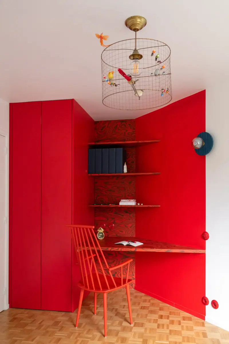 The study picks one color and doesn't let go — walls, cabinetry and desk all drenched in red.Sabine Serrad. Design: Célia Reubrecht