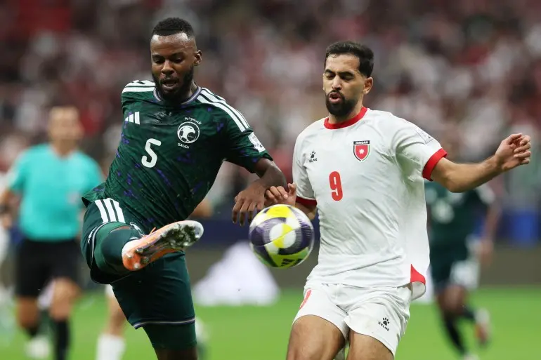 Soccer Football - FIFA Arab Cup - Qatar 2025 - Semi Final - Jordan v Saudi Arabia - Al Bayt Stadium, Al Khor, Qatar - December 15, 2025 Saudi Arabia's Hassan Tambakti in action with Jordan's Ali Iyad Ali Olwan REUTERS/Ibraheem Al Omari