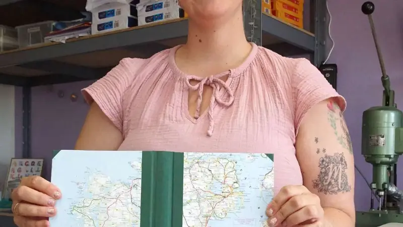 Eines der beliebten Reisetagebücher zeigt Sabine Pezala, hier mit der Landkarte von Irland.
