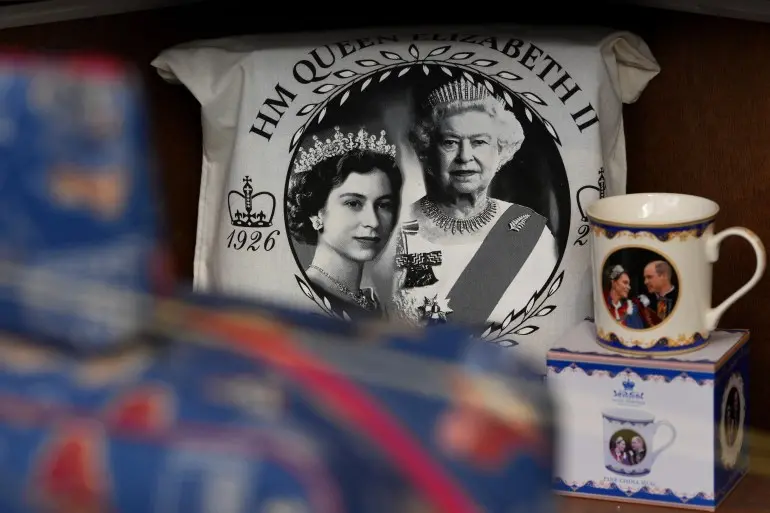 Souvenirs with photos of late Queen Elizabeth II are on display for sale at a souvenirs shop in London, on April 17, 2026. (AP Photo/Kin Cheung)