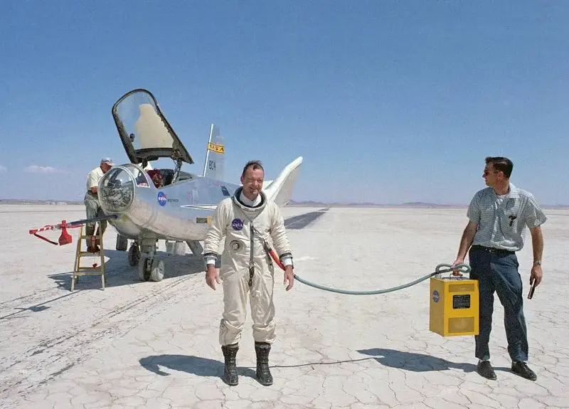 NASA research pilot Bill Dana wearing a pressure suit beside the HL-10 lifting-body aircraft