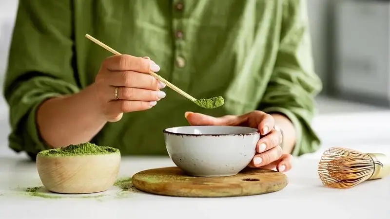 Woman brewing matcha in traditional fashion