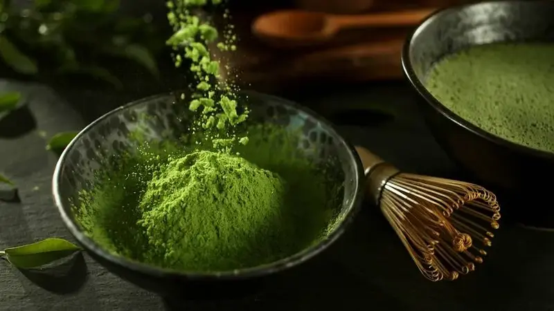Matcha powder next to whisk