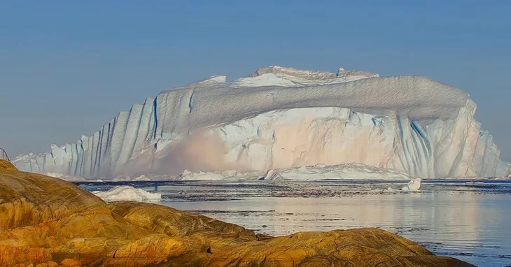 A giant iceberg flips over near Greenland, revealing its deep blue 'ice belly' - Photo 1.