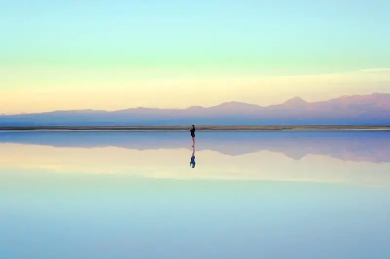 https://freerangestock.com/sample/180729/person-standing-on-reflective-surface-in-serene-landscape.jpg
