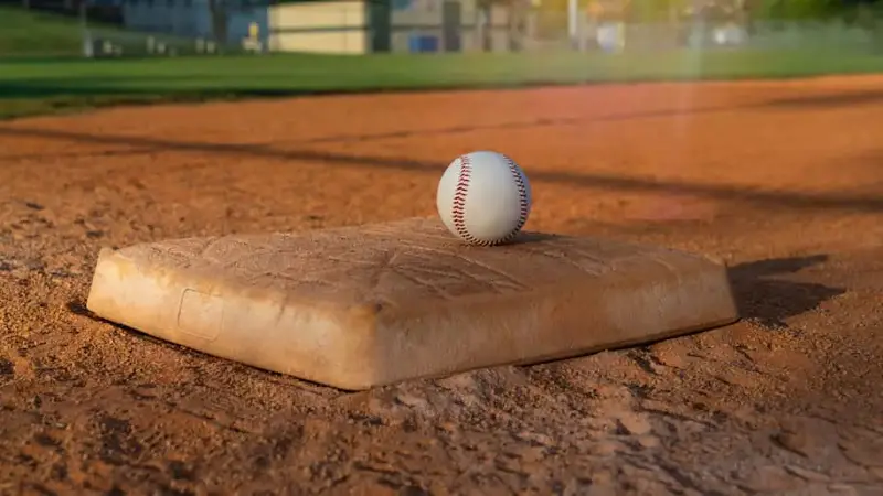 Baseball on a Base in the Infield Backlit by the Sun