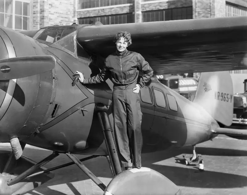 (Original Caption) Amelia Earhart (1898-1937), American aviatrix, first woman to cross Atlantic. Photograph showing her with airplane.