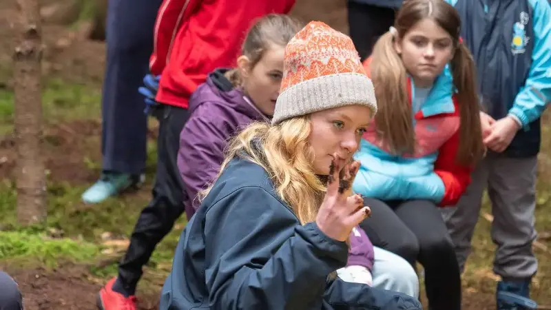Lilith Vetter von der Schutzgemeinschaft Deutscher Wald erklärt, wie die Kinder einen Baum richtig pflanzen.
