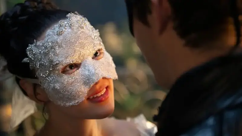 Sophie from 'Bridgerton' gazes upward wearing a bejeweled mask