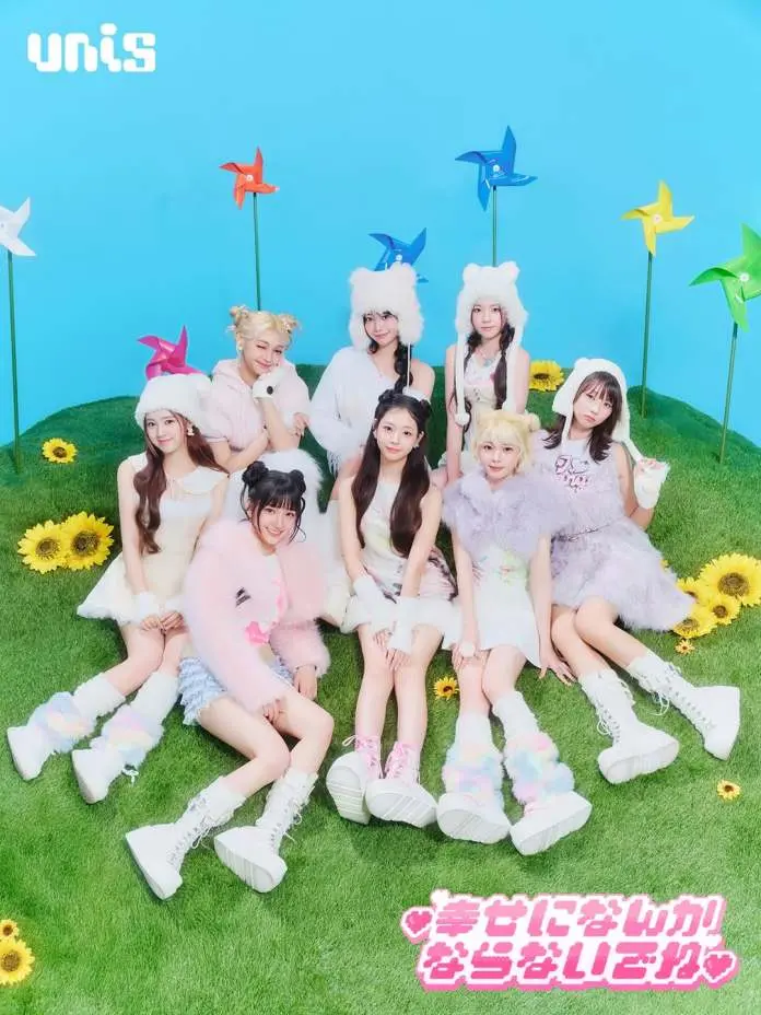 UNIS posing together on green grass, surrounded by colorful pinwheels and sunflowers, wearing cute, pastel outfits and boots against a bright blue background.