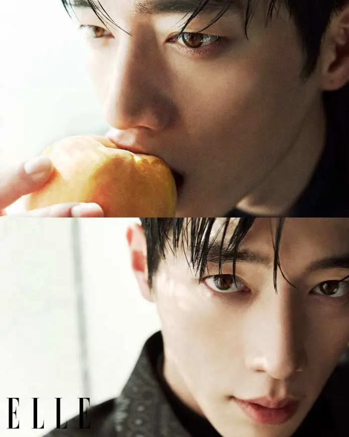 Seo Kang-joon with wet black hair, holding a peach close to his mouth, looking contemplative.