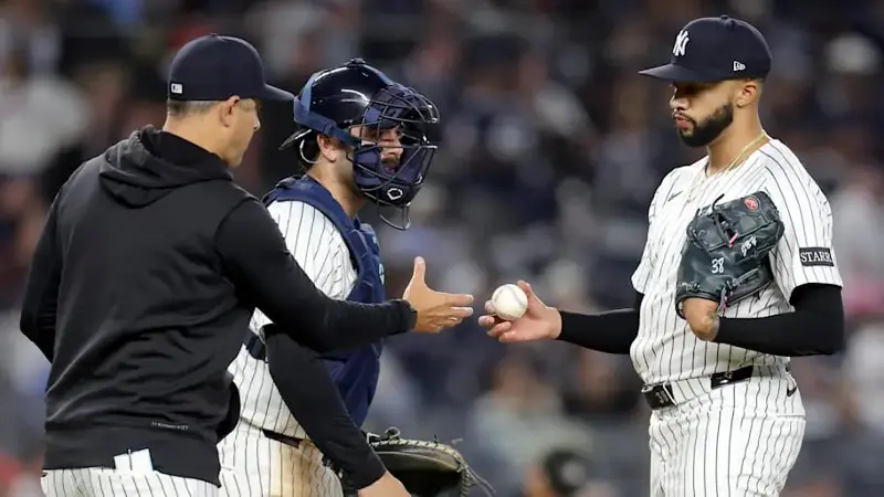 New York Yankees manager Aaron Boone (17) takes the ball from relief pitcher Devin Williams (38) during a pitching change dur