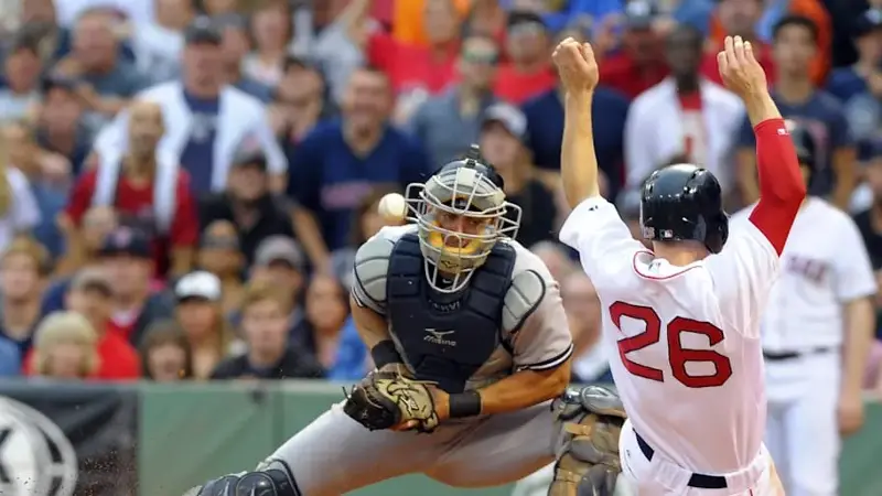 Boston Red Sox third baseman Brock Holt (26) slides safely into home plate past New York Yankees catcher Francisco Cervelli 