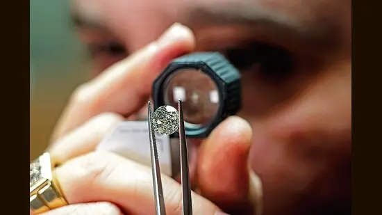 A polished natural diamond is examined through a loupe.