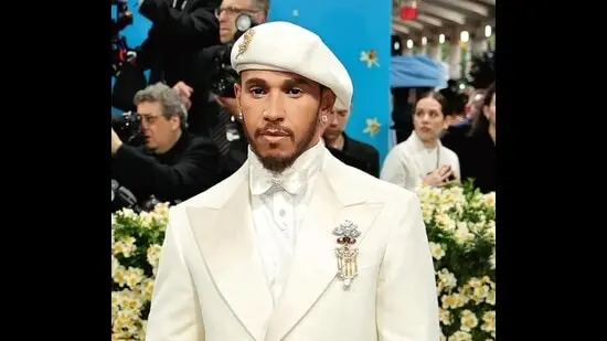 Lewis Hamilton at the 2025 Met Gala. He wore a floral brooch set with white, yellow and pink diamonds, paired with diamond studs.
