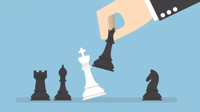 Businessman hand use black queen checkmate the white king