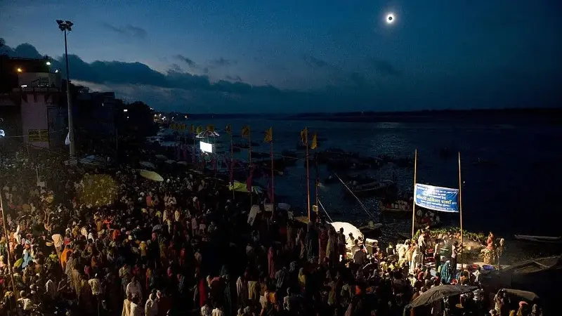 Thousands of people gather to watch a solar eclipse along the Ganges River in the Indian city of Varanasi on July 22, 2009.