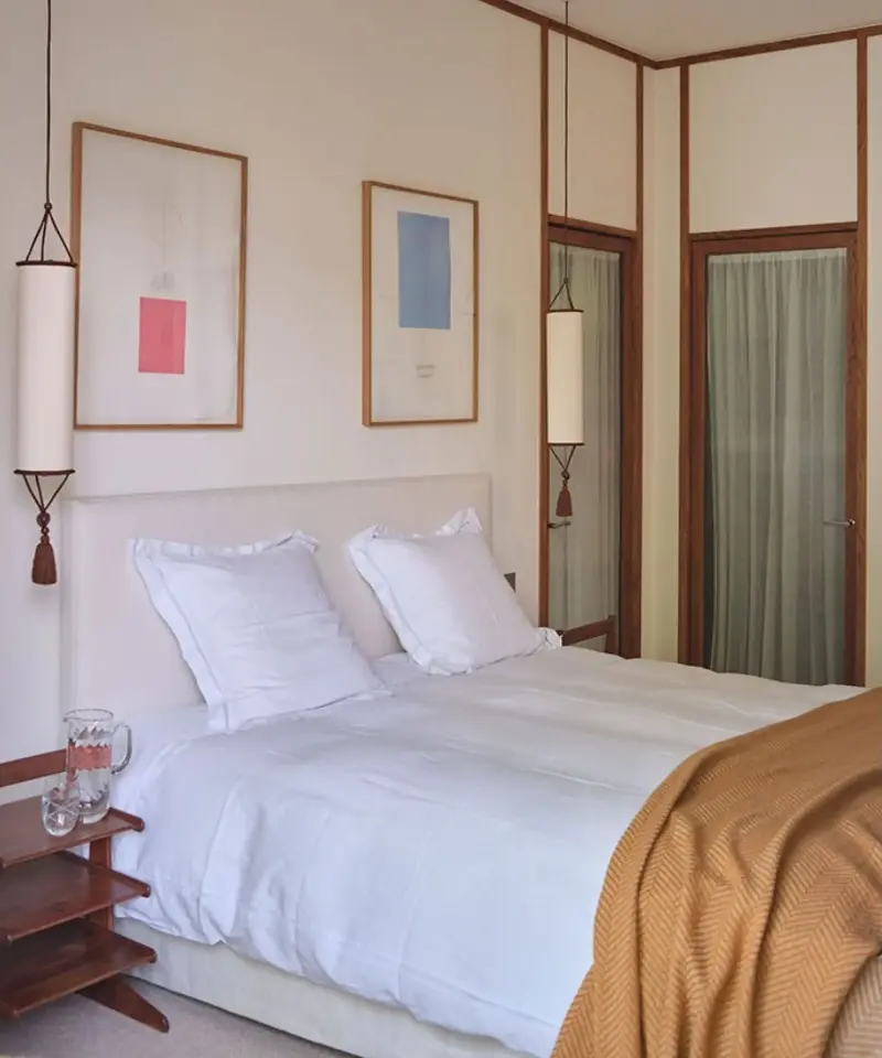 Two tasseled Betty pendant lights by Hauvette & Madani frame the bed in this otherwise pared-back bedroom. (Image credit: Hauvette & Madani)