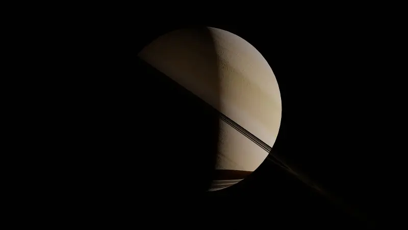 Saturn and its rings against the dark of space; Titan, where Huygens landed, is Saturns largest moon.