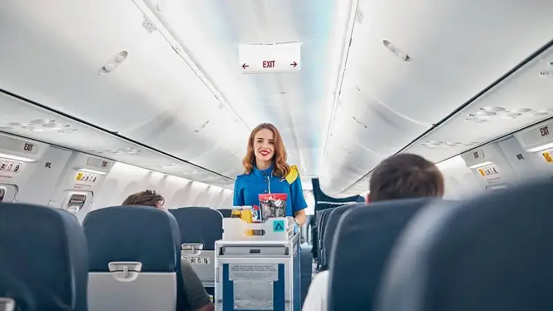 Stewardess coming down airplane aisle